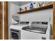 Well-organized laundry room equipped with modern washer and dryer and storage shelf for convenience at 525 Penny Ln, Woodstock, GA 30188