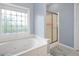 Bright bathroom features a soaking tub with jets and a decorative window at 5628 Harbormist Dr, Powder Springs, GA 30127