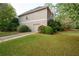 View of the home's exterior showing the 1-car garage and well-maintained lawn and landscaping at 5628 Harbormist Dr, Powder Springs, GA 30127