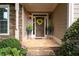 Close-up of a stone front porch, adorned with potted plants and a wreath on the front door at 5628 Harbormist Dr, Powder Springs, GA 30127
