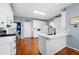 Bright, all-white kitchen featuring modern appliances, stone countertops, and hardwood flooring at 5628 Harbormist Dr, Powder Springs, GA 30127