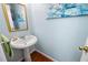 Cozy powder room with hardwood floors, a pedestal sink, and decorative art at 5628 Harbormist Dr, Powder Springs, GA 30127