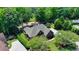 Aerial view showcasing the home's well-manicured lawn and lush surrounding greenery at 7020 Grassmoor Grange Way, Cumming, GA 30040