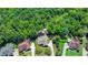 An aerial view of a home nestled among lush greenery showcasing its well-manicured lawn and surrounding trees at 7020 Grassmoor Grange Way, Cumming, GA 30040