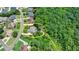 Bird's eye view of a cozy house surrounded by mature trees in a neighborhood with lush greenery and well-maintained streets at 7020 Grassmoor Grange Way, Cumming, GA 30040