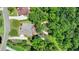 An aerial view showcases a backyard, with a deck, of a charming suburban home backing onto a lush green forest at 7020 Grassmoor Grange Way, Cumming, GA 30040