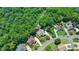 Aerial view of a suburban home with a well-kept lawn, mature trees, and neighboring houses at 7020 Grassmoor Grange Way, Cumming, GA 30040