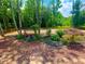 Landscaped backyard area with garden features and wooded backdrop at 7020 Grassmoor Grange Way, Cumming, GA 30040