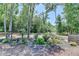 Landscaped backyard features decorative rock, mature trees, and garden elements, creating a peaceful outdoor setting at 7020 Grassmoor Grange Way, Cumming, GA 30040