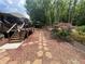 Tranquil backyard features stone path, lush landscaping, and a deck perfect for enjoying the outdoors at 7020 Grassmoor Grange Way, Cumming, GA 30040