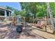 Backyard oasis with wooden swing sets, fire pit, mature trees, and a privacy fence for secluded outdoor enjoyment at 7020 Grassmoor Grange Way, Cumming, GA 30040