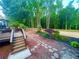Expansive backyard with a deck, stone path, and mature trees, creating a peaceful outdoor retreat at 7020 Grassmoor Grange Way, Cumming, GA 30040
