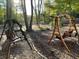 Inviting backyard features two wooden swings perfect for relaxing in the landscaped and woodsy surroundings at 7020 Grassmoor Grange Way, Cumming, GA 30040