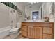 Well-maintained bathroom featuring a bathtub, commode, and vanity with wooden cabinetry at 7020 Grassmoor Grange Way, Cumming, GA 30040