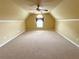 Large bonus room with neutral carpet, bright window, and ceiling fan at 7020 Grassmoor Grange Way, Cumming, GA 30040
