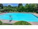 Well-maintained community pool featuring a lifeguard stand, lounge chairs, and manicured landscaping at 7020 Grassmoor Grange Way, Cumming, GA 30040