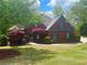 Charming red brick home with manicured landscaping, mature trees, and lovely curb appeal at 7020 Grassmoor Grange Way, Cumming, GA 30040