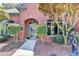 Charming brick home with arched entryway, manicured landscaping, and mature trees enhancing curb appeal at 7020 Grassmoor Grange Way, Cumming, GA 30040