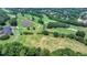 Aerial view of a lush golf course with green fairways, mature trees, and manicured lawns at 7020 Grassmoor Grange Way, Cumming, GA 30040