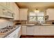 Clean kitchen with gas range, white cabinets, stainless steel appliances and tile backsplash at 7020 Grassmoor Grange Way, Cumming, GA 30040