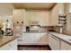 A full kitchen featuring granite countertops, white cabinets, stainless steel microwave and wall oven at 7020 Grassmoor Grange Way, Cumming, GA 30040