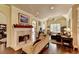 Open-concept living space with hardwood floors, a fireplace, and plenty of natural light at 7020 Grassmoor Grange Way, Cumming, GA 30040