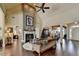 Open-concept living room with fireplace, ceiling fan, and hardwood flooring at 7020 Grassmoor Grange Way, Cumming, GA 30040