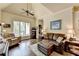Inviting living room featuring hardwood floors, a ceiling fan, and a large window for natural light at 7020 Grassmoor Grange Way, Cumming, GA 30040