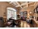 Stylish home office with coffered ceiling, a large window, and built-in bookshelves at 7020 Grassmoor Grange Way, Cumming, GA 30040