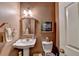 Cozy powder room with pedestal sink, decorative mirror, and soft lighting at 7020 Grassmoor Grange Way, Cumming, GA 30040