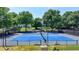 Community tennis courts feature bright blue courts with black fencing and benches, surrounded by green trees at 7020 Grassmoor Grange Way, Cumming, GA 30040