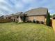 Grassy backyard featuring a covered patio, manicured landscaping, and privacy fence at 725 Valley Glen Dr, Dacula, GA 30019