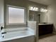 Spacious bathroom featuring a garden tub and a dark wooden vanity at 725 Valley Glen Dr, Dacula, GA 30019