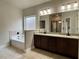 Bathroom featuring double sinks, a garden tub and a walk-in shower at 725 Valley Glen Dr, Dacula, GA 30019