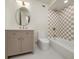 Bright bathroom featuring a modern vanity with gold fixtures, a unique mirror, and a tiled shower/tub with checkered tile at 2569 Woodhill Ln, Atlanta, GA 30344