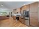 Modern kitchen featuring stainless steel appliances, wood cabinets, and light hardwood floors at 2569 Woodhill Ln, Atlanta, GA 30344