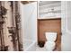 Cozy bathroom showcasing a shower with unique curtain, toilet, and shelving for towels at 3902 Butterstream Nw Way, Kennesaw, GA 30144