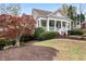 Beautiful front lawn and home with a covered porch, complemented by mature trees at 3902 Butterstream Nw Way, Kennesaw, GA 30144