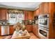 Modern kitchen boasting wood cabinets, stainless steel appliances, granite countertops, and bright window at 3902 Butterstream Nw Way, Kennesaw, GA 30144