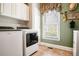 Functional laundry room featuring modern appliances, window, and tile flooring at 3902 Butterstream Nw Way, Kennesaw, GA 30144