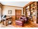 Cozy home office featuring custom built-in bookshelves, hardwood floors and wood-paneled walls at 3902 Butterstream Nw Way, Kennesaw, GA 30144