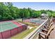 Community tennis courts and seating area overlooking a court and wooded landscape at 3902 Butterstream Nw Way, Kennesaw, GA 30144