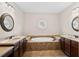 Large bathtub with tile surround and dual vanities with granite countertops at 4535 Meadow Green Ln, Acworth, GA 30101
