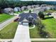 Aerial view of a two-story home showcasing a manicured lawn and mature trees in a residential neighborhood at 6793 Oconee Pl, Fairburn, GA 30213