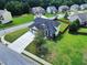 A house features a well-kept lawn, a long driveway, and a two-car garage in a neighborhood with mature trees and landscaping at 6793 Oconee Pl, Fairburn, GA 30213