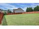 View of the backyard featuring a large, grassy lawn and a wood privacy fence at 6793 Oconee Pl, Fairburn, GA 30213