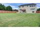 Spacious backyard with a large lawn and wood fence, and the home's back elevation at 6793 Oconee Pl, Fairburn, GA 30213