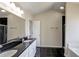 Bathroom with double sinks, black granite countertops, and white cabinetry at 6793 Oconee Pl, Fairburn, GA 30213