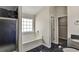 Bathroom featuring a soaking tub, walk-in shower with black tiling, and black tile flooring at 6793 Oconee Pl, Fairburn, GA 30213