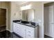 Bathroom with double sinks, a large mirror, and black granite countertops at 6793 Oconee Pl, Fairburn, GA 30213